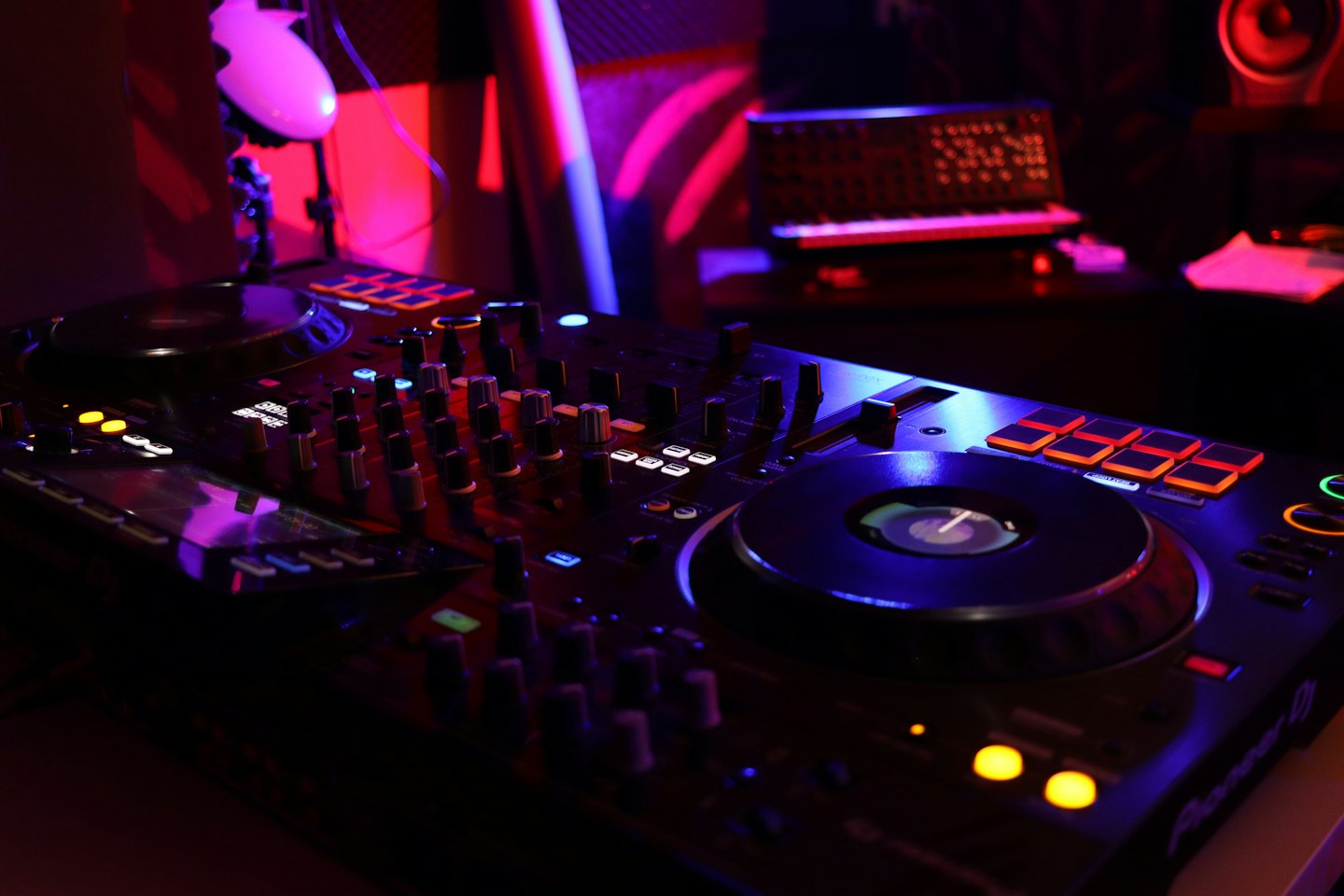 Controlador de DJ con botones brillantes y luces de colores.